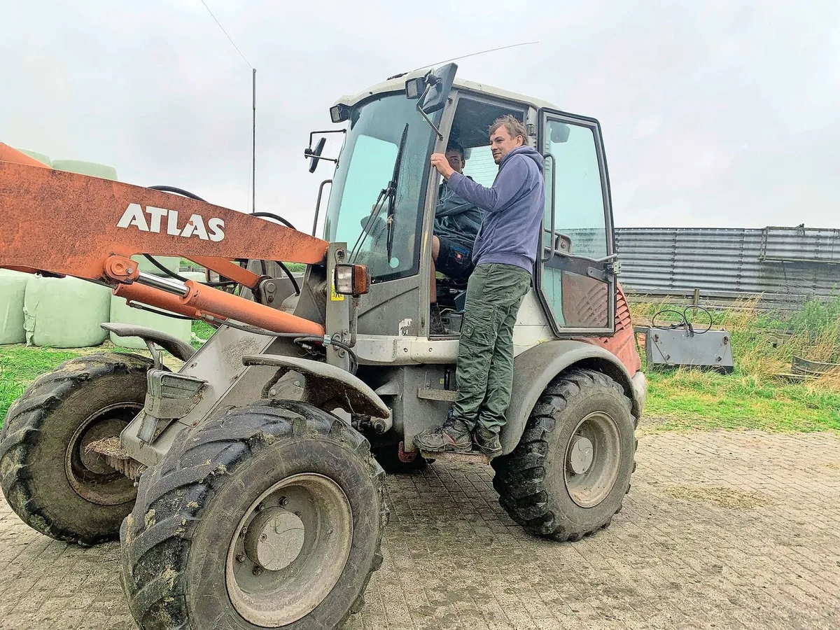 Jannik ist schon ziemlich geübt im Umgang mit den Maschinen. Lehrmeister Timo gibt ihm kurz eine Instruktion beim Siloballenfahren.