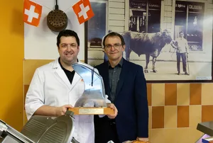 Roberto Luisoni präsentiert mit Stolz seinen Pokal, einer aus einem Blitzmesser gefertigten Uhr. Übergeben wurde ihm die Auzeichnung von Ruedi Hadorn, Direktor des Schweizer Fleisch-Fachverbands. (Hinweis: Die Masken wurden unter Einhaltung des Schutzkonzepts nur kurzzeitig für die Aufnahme abgenommen.) (Bild SFF)