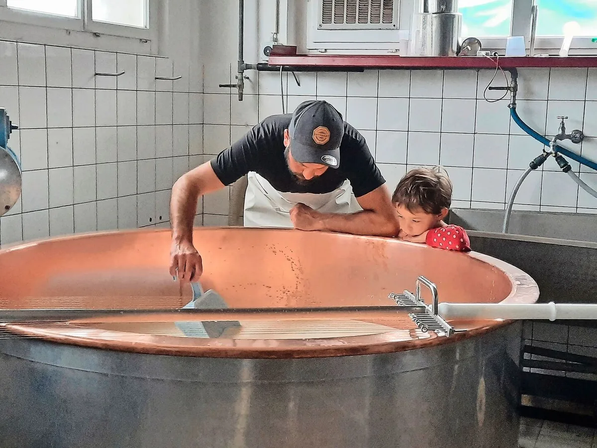 Die viereinhalbjährige Ronya liebt es, in der Sennerei zu sein. Fasziniert schaut sie zu, was mit der Milch im Kessi passiert und was genau ihr Vater macht.