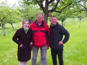 Gastgeber Jakob Kaufmann in seinem Hochstammobstgarten, umringt von Hochstamm Suisse Co-Präsidentin Maya Graf und Geschäftsführer Pierre Coulin. (Bild zVg)