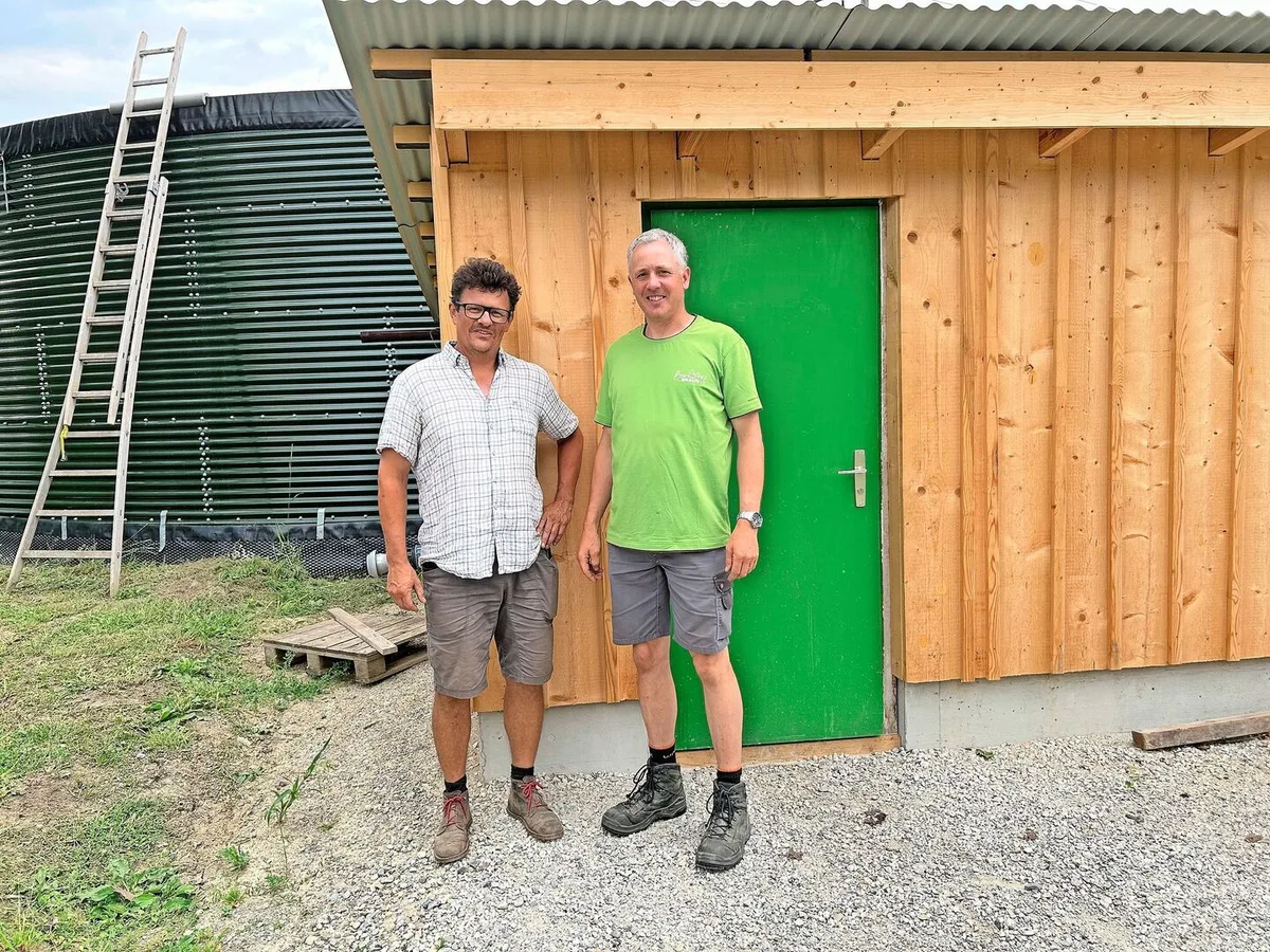 ccc4e64baefb163c213016089d3353820172e28e0d7805175650222b0d6a6dbd Rolf Mengelt und Andreas Braun (v. l.) stehen vor dem Pumpenhäuschen. Hinter ihnen ist ihr grünes Wasserreservoir zu sehen, das von Grundwasser gespeist wird. Von dort wird das Wasser in ihre Felder geleitet.