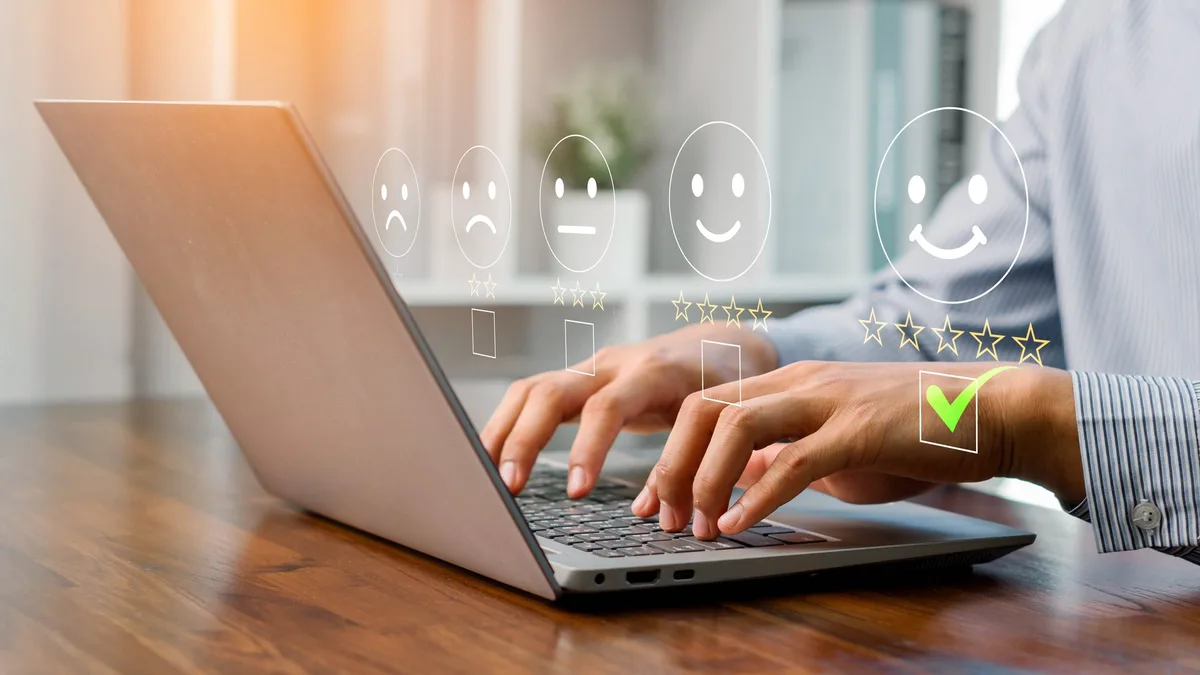 AdobeStock_1774236675 A person using a laptop to rate customer satisfaction with five-star feedback, showing online service quality, user experience, digital communication, and business review for marketing and improvement