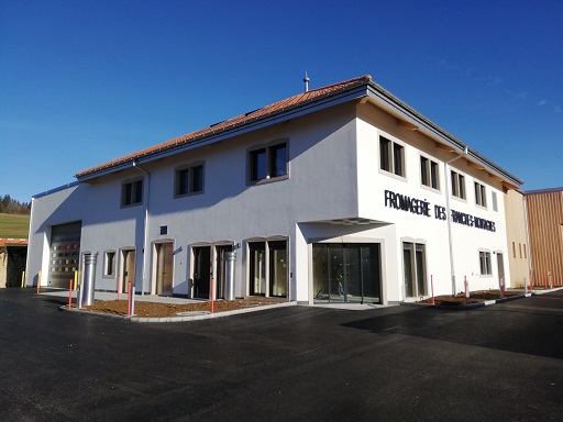 Die neue Käserei in Le Noirmont JU ist ein moderner Neubau mit Robotern im Keller und Solarplatten auf dem Dach. (Bild Fromagerie des Franches-Montagnes)