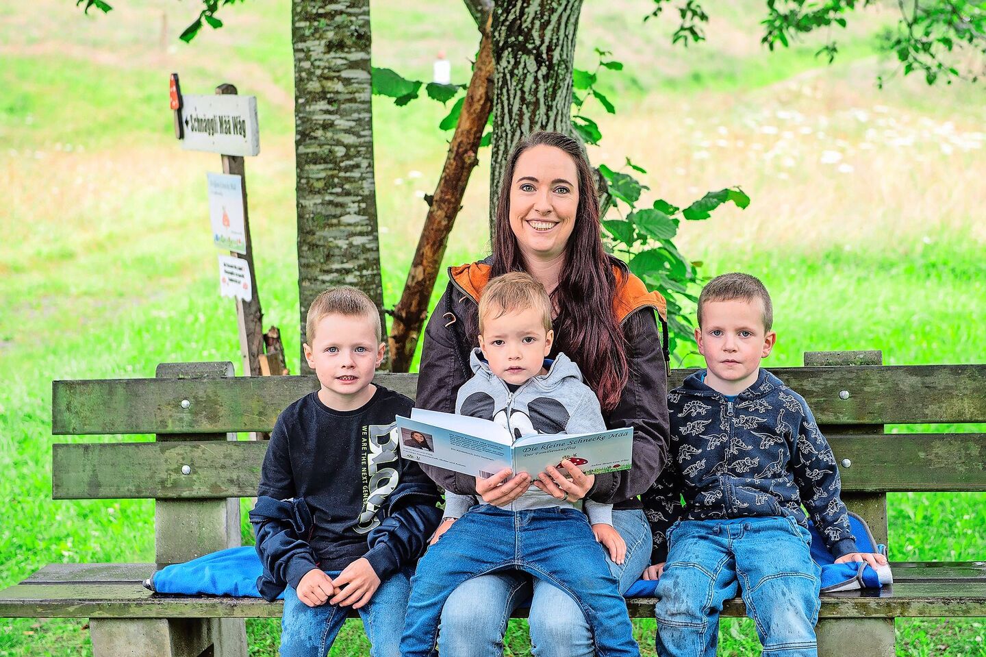 Sahra Brun-von Flüe mit ihren drei Buben (v. l.) Noah (6,5), Fabio (2,5) und Dario (4,5) am Büechli lesen beim Start des Themenweges bei der Bohrplatte Finsterwald.