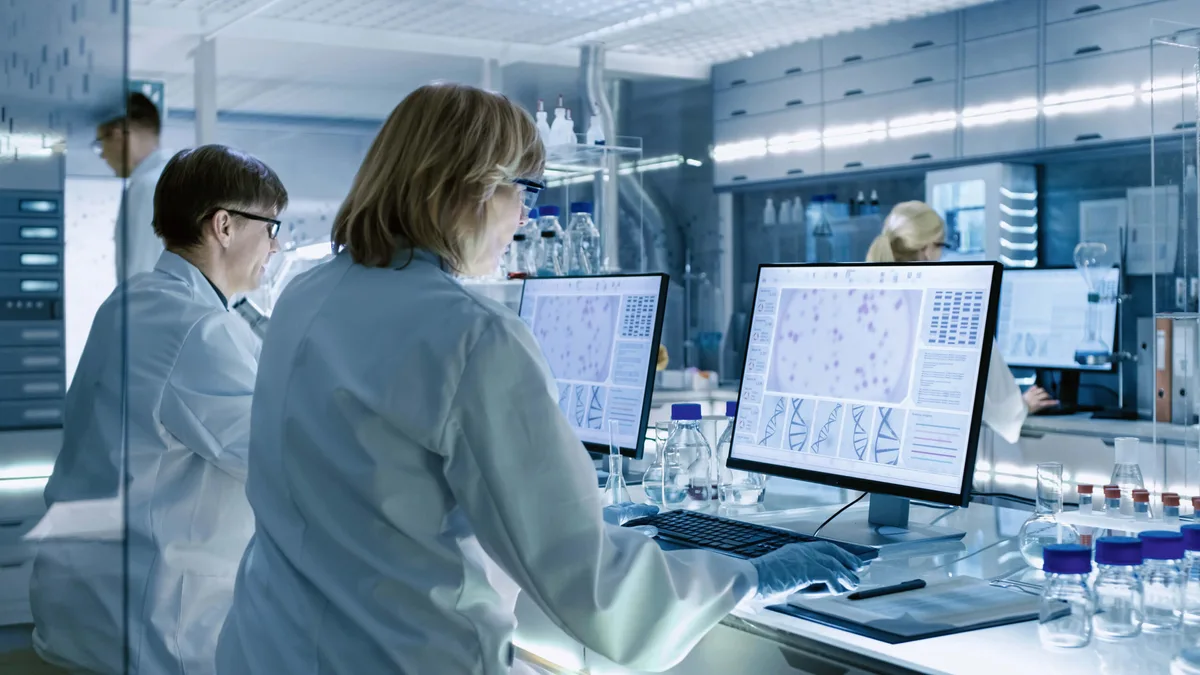 genschere_crispr-cas_labor Labor mit Bildschirmen, auf denen Gensequenzen zu sehen sind.
