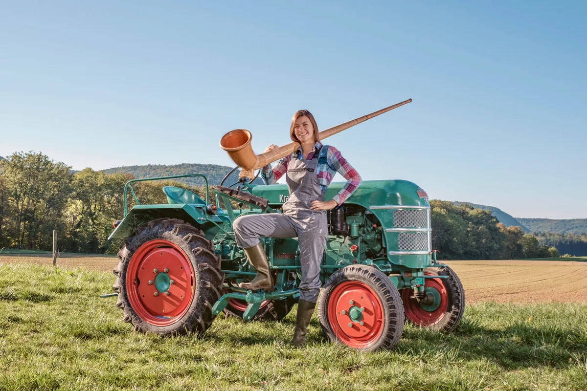 d1b5091bc82e6672883f65daf1b26df4ad6084c1 Alphorn-Solistin Lisa Stoll mit ihrem «Traum-Traktor», einem Kramer K15. Bild: zVg