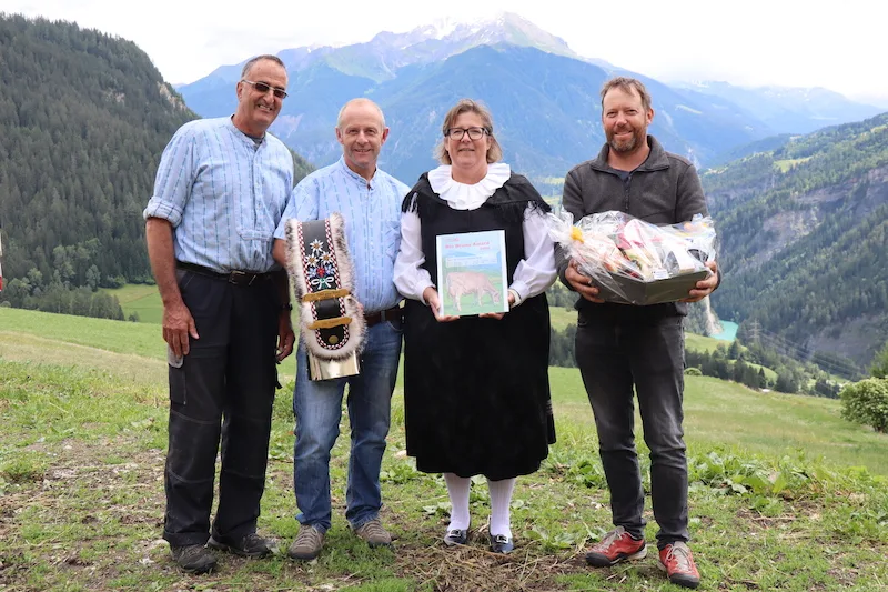 dbf651f0ab633f0da2b92eef3e7a02db7bffca05 Als Anerkennung ihrer Leistung wurden Toni (mit Glocke) und Nicole Sigron (mit Bio Bruna Award) von Marco Parpan (l.) Lucas Margreth (r.) mit einem Früchtekorb beschenkt. (Bild vcd)
