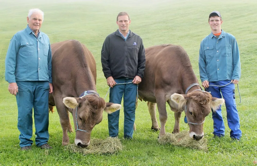 Drei Züchtergenerationen auf dem Betrieb Egli: Vater Hans, Betriebsleiter Hanspeter und Sohn Silvan mit ihrer Schöneutersiegerin Kroni und der Miss Raja. (Bild: Reto Betschart)