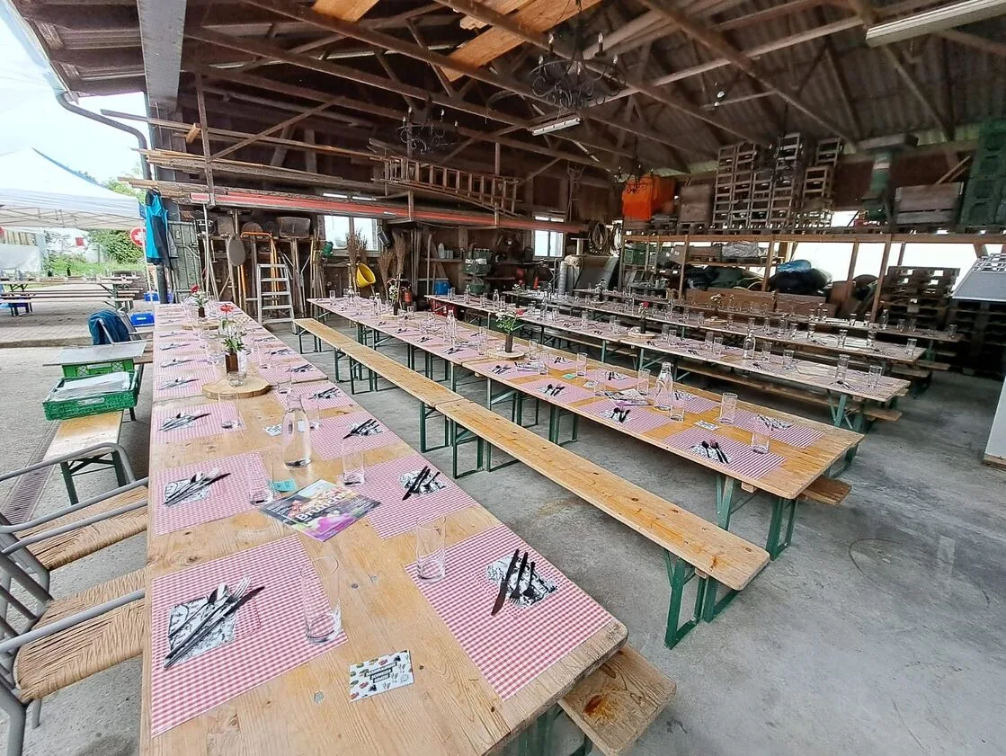 Aus- und aufgeräumte Remise mit gedeckten Tischen, bereit für den Brunch auf dem Betrieb Wyssrüti.