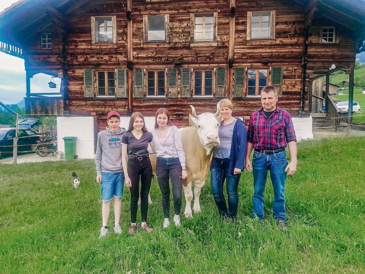 Tanja und Abraham Aellig mit den Kindern Martina, Ursina und Andrin. An der Halfter die Kuh Stella.