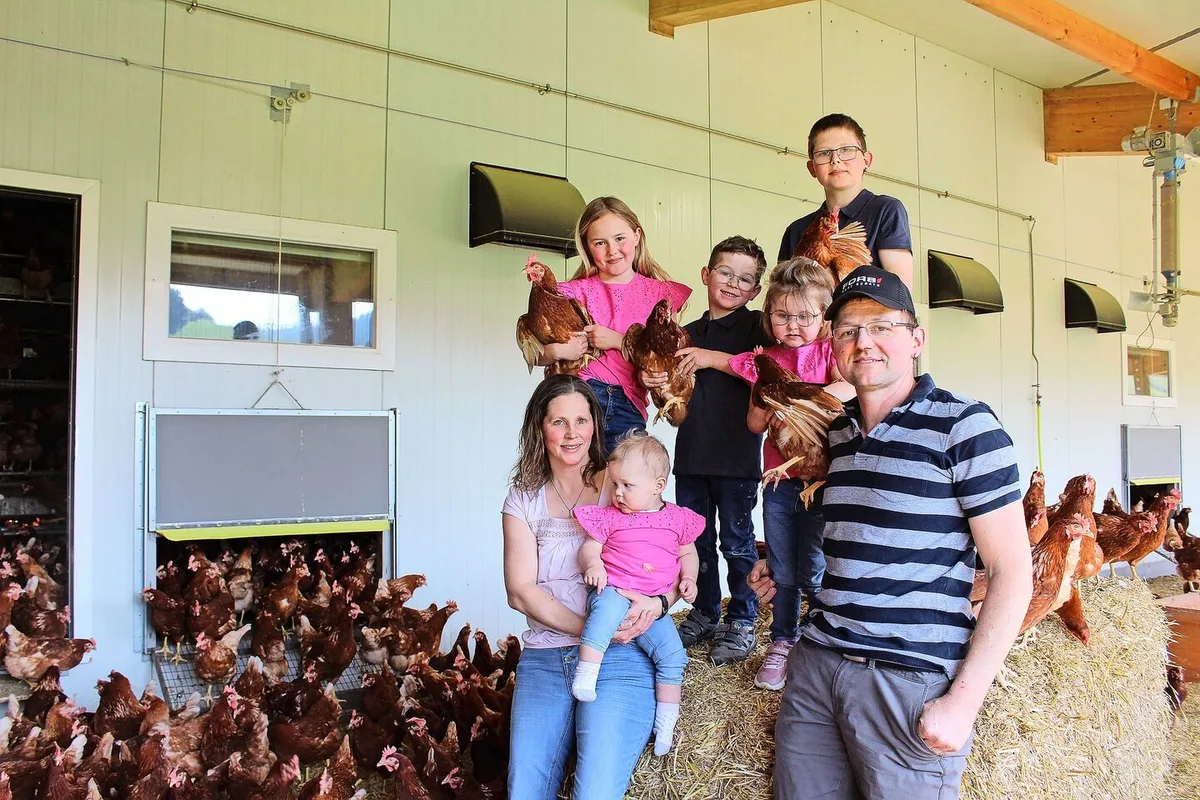 dddcfc81d425ce8ce0676da3ccc39ede5f472f2eb5478ae88d9772061b6461eb Patrizia und Christian Bamert-Weishaupt mit ihren Kindern Jonas, Angelika, Reto, Lilian und Andreina, umgeben von ihren Legehennen. Neben Hühnern halten sie auch Rinder und Milchkühe.