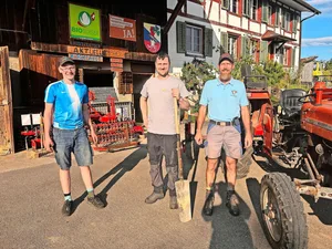 Junior Laurin Moser, Strickhofberater Serge Braun und Betriebsleiter Res Moser zeigten die Vorteile von Untersaaten auf. Im Hintergrund die Gerätschaft für die Bodenbearbeitung.