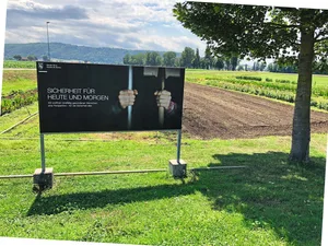 Erst auf den zweiten Blick erkennt man, dass auf dem Plakat der JVA eine Hand ein Zellengitter und die andere den Stiel einer Schaufel umfasst.