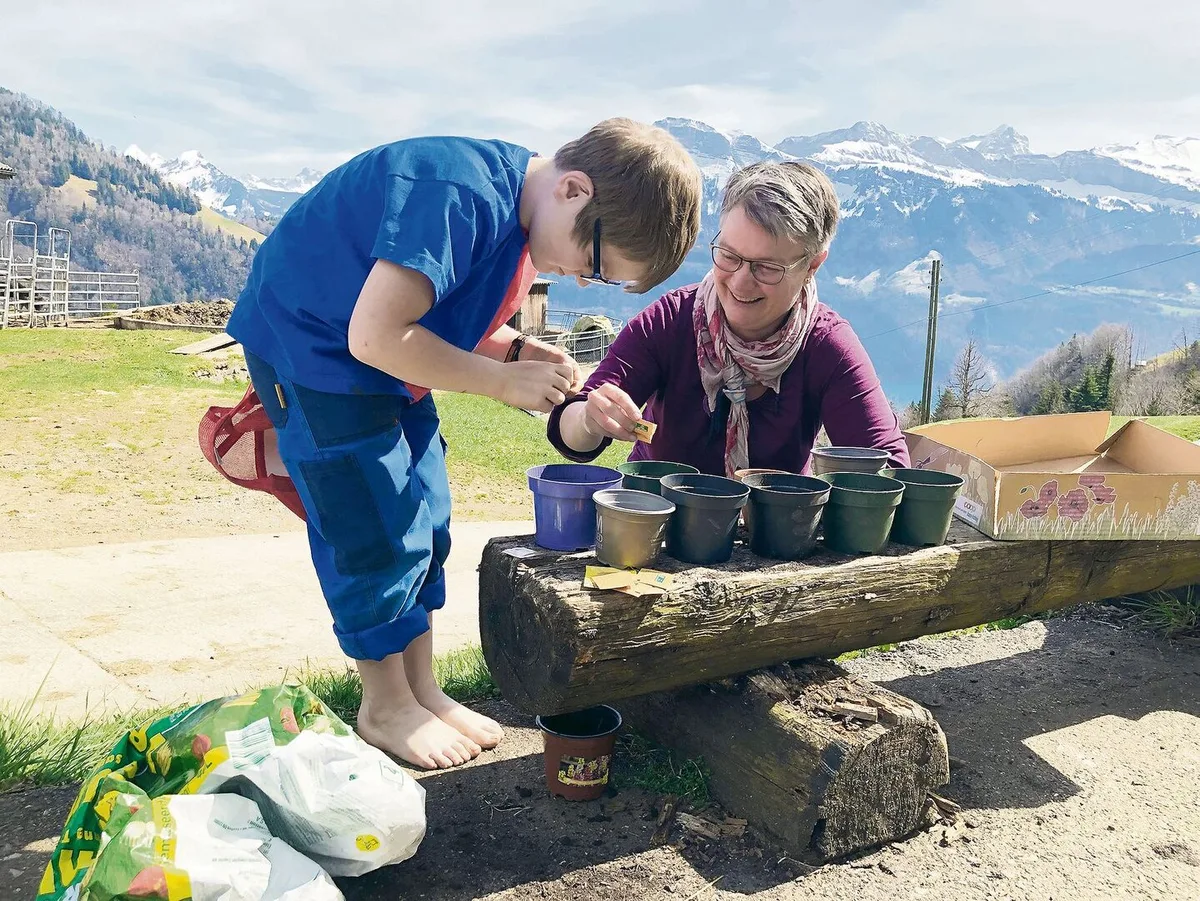 Edith Camenzind mit ihrem jüngsten Sohn Felix. Sie pflanzen gemeinsam Sonnenblumen.