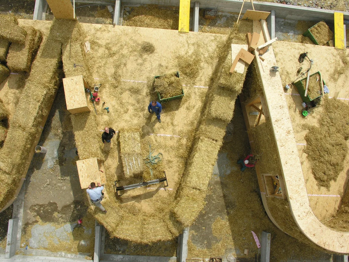 e03c6c53abf8927e5474e1e0870d78b474fc5e60 Die Strohballen bestimmen die Dicke der Wände und werden in die Holzkonstruktion eingefüllt und zugeschnitten. Das atmungsaktive Stroh wirkt wegen seiner tiefen Wärmeleitfähigkeit wärmedämmend und somit isolierend. (Bild Atelier Schmidt)