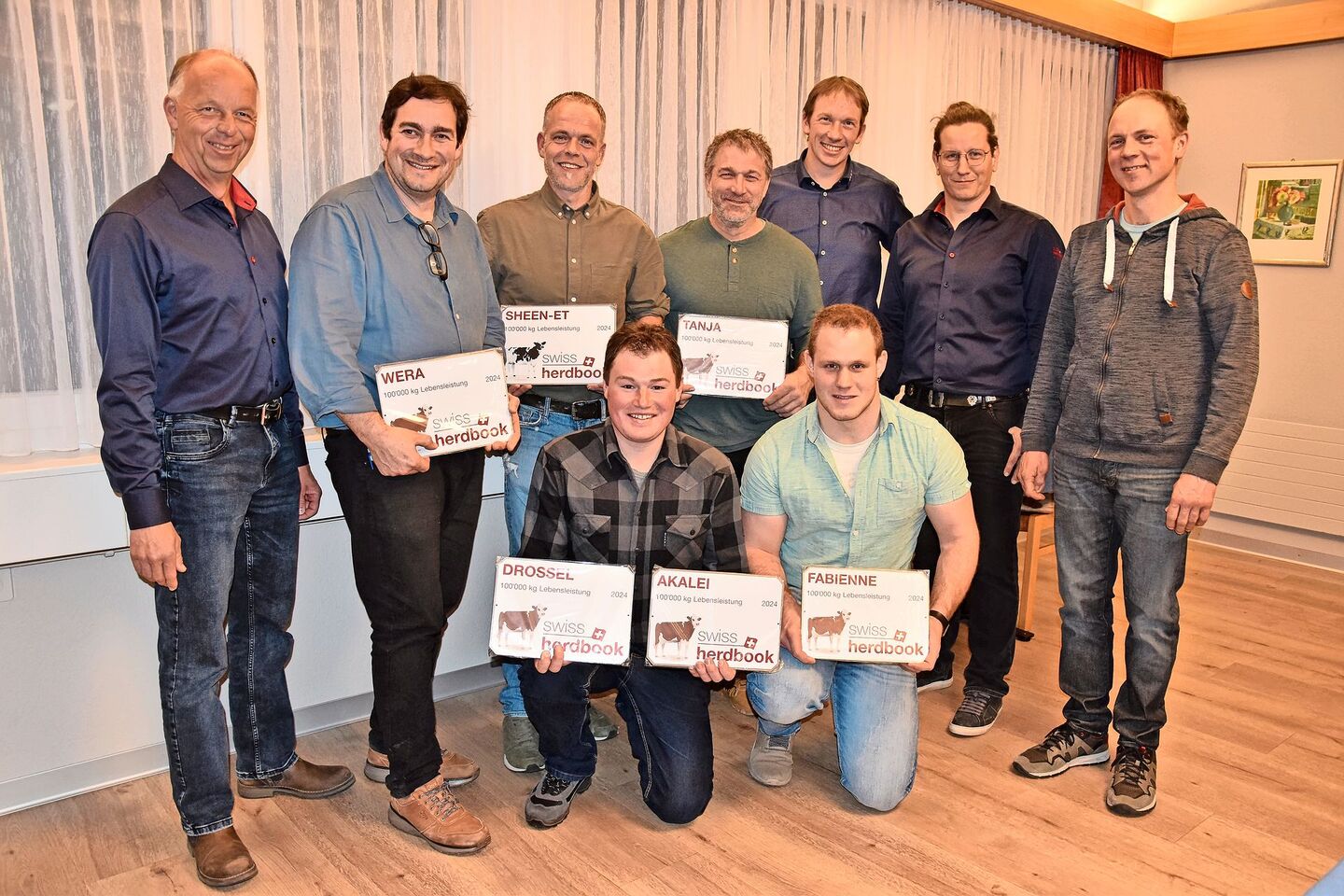 Die stolzen Besitzer der 100 000er-Kühe (mit Plaketten), umrahmt von Adrian Weber, Christian Burkhalter, Nicolas Berger und Adrian Aebersold (von links)