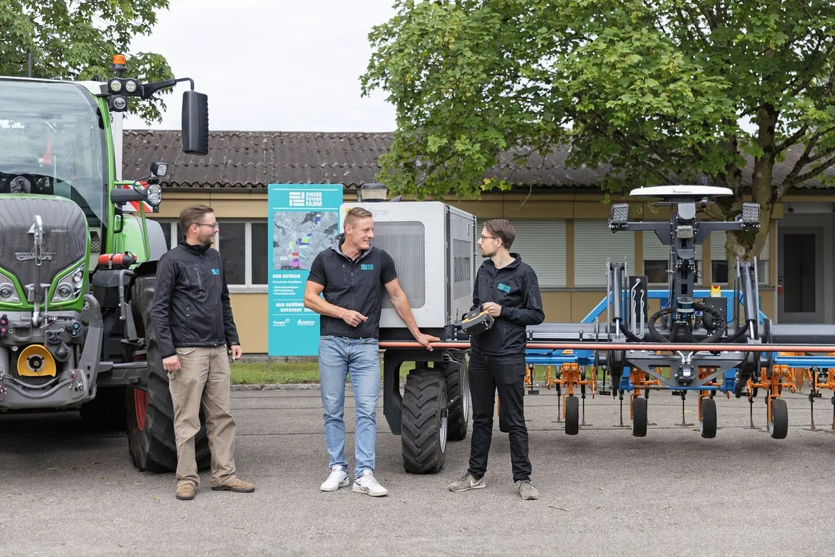 Nils Zehner (AGCO) Roman Gambirasio (GVS)und Florian Abt (Arenenberg) stehen vor einem Fendt-Traktor sowie einem Feldroboter.
