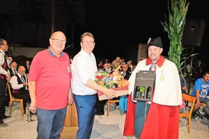 Urs Stähli, Präsident des Schützenvereins Ossingen, dankt Bundesrat Albert Rösti mit einem grossen Geschenkkorb und drei Flaschen Wein, die sein Weibel Carlo Pfister für ihn in der Hand hält (v. l.).