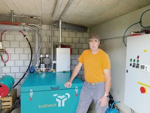 Beat Schürch vor dem Blochkeizkraftwerk seiner Biogasanlage. Die effiziente Anlage nimmt nur wenig Platz ein.