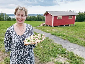 Riitta Okkonen (56) hat den ehemaligen Kleinbetrieb der Eltern zum Agrotourismushof umgebaut. Rechts ein Gästeblockhaus.