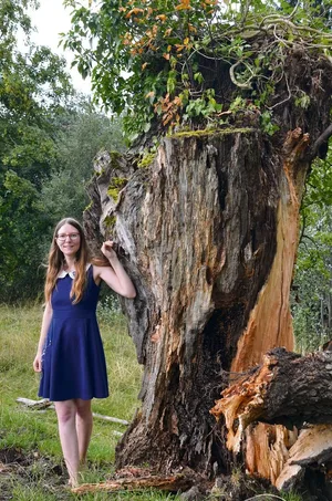 Tina Matzinger neben einem der Bäume, die von einem Sturm beschädigt wurden. Er darf stehen bleiben, da sich im Totholz Insekten ansiedeln.