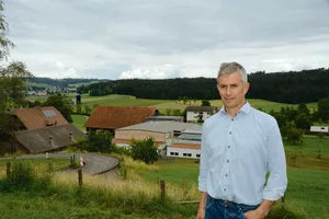Die Bauphase ist abgeschlossen: Franzsepp Erni mit Hofgruppe im Hintergrund. Der Stall für die 100 Muttersauen ist zweistöckig und wirkt kompakt. (Bilder Armin Emmenegger)