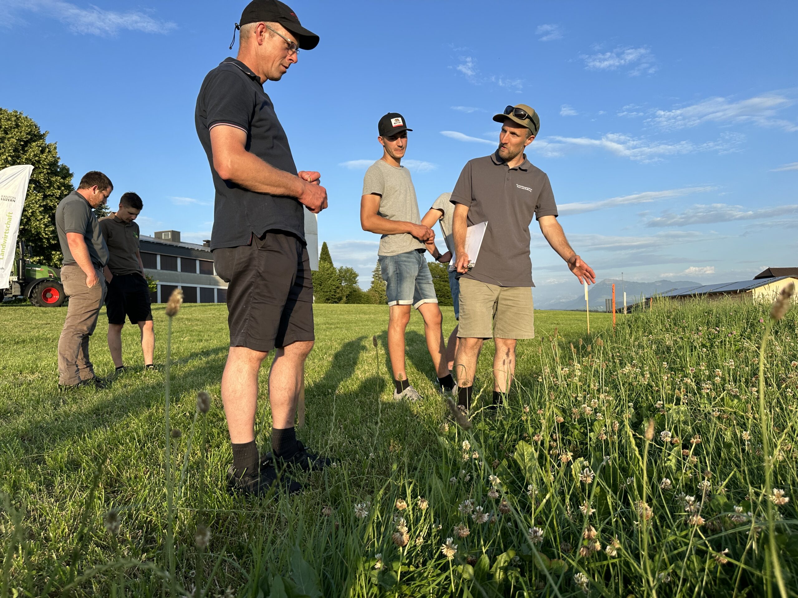 Dominik Amrein (r.) erläutert die Unterschiede der verschiedenen Wiesenmischungen beim BBZN Hohenrain.