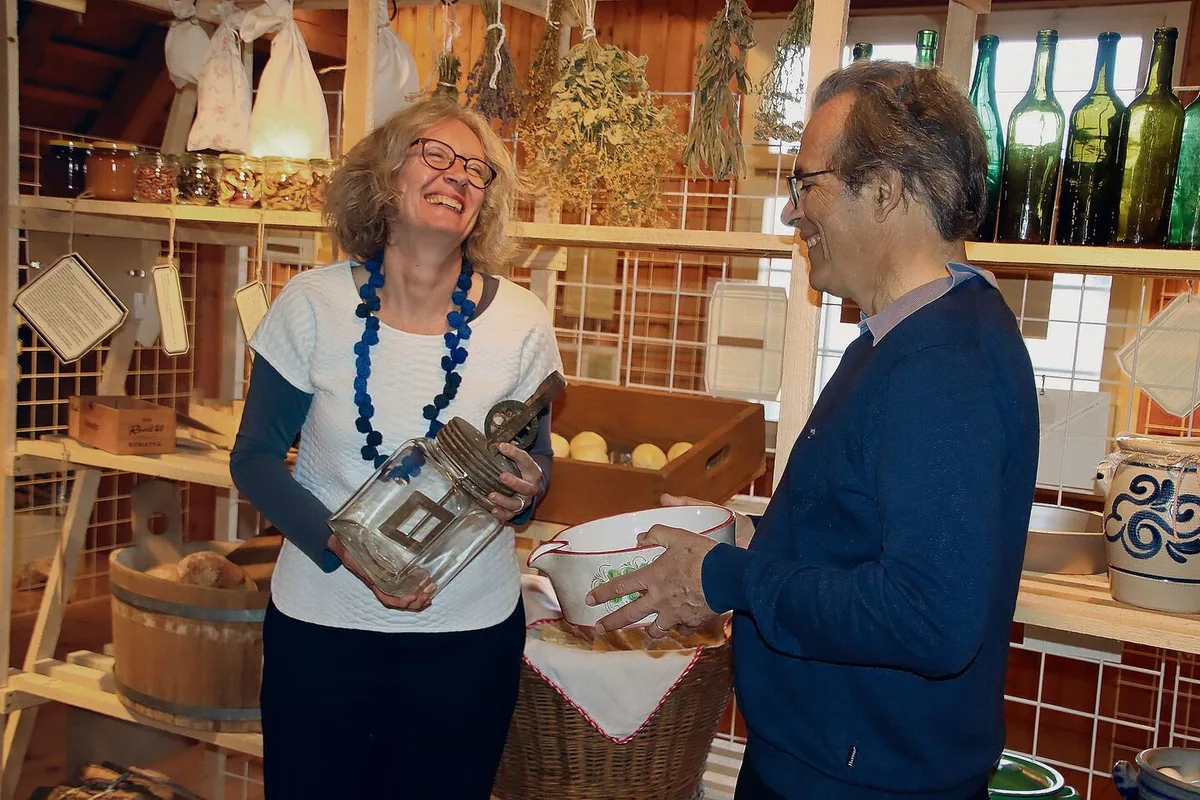 e2fa8e87cacb22402ee1e82281de505984fa8b4eeee93440855842fac579dfed Susanne Grieder mit Butterglas und Viktor Ledermann mit einem Entrahmungsbecken freuen sich über die Ausstellung.