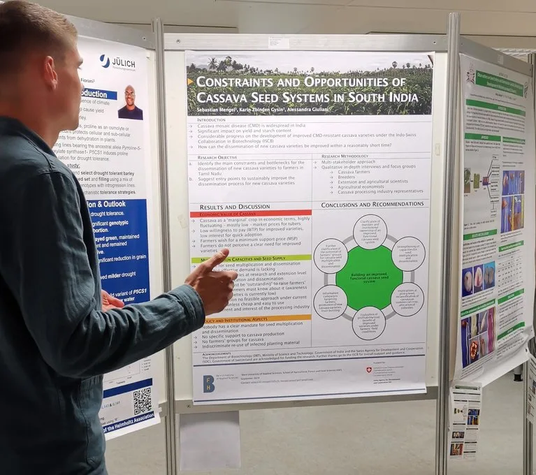 d4d99e2a1034f4d705b48ee7e273c9848c87beb5 Ein Studierender der Berner Fachhochschule stellt sein Poster zur Cassava-Vermehrung in Südindien vor. (Bild lid/mg)
