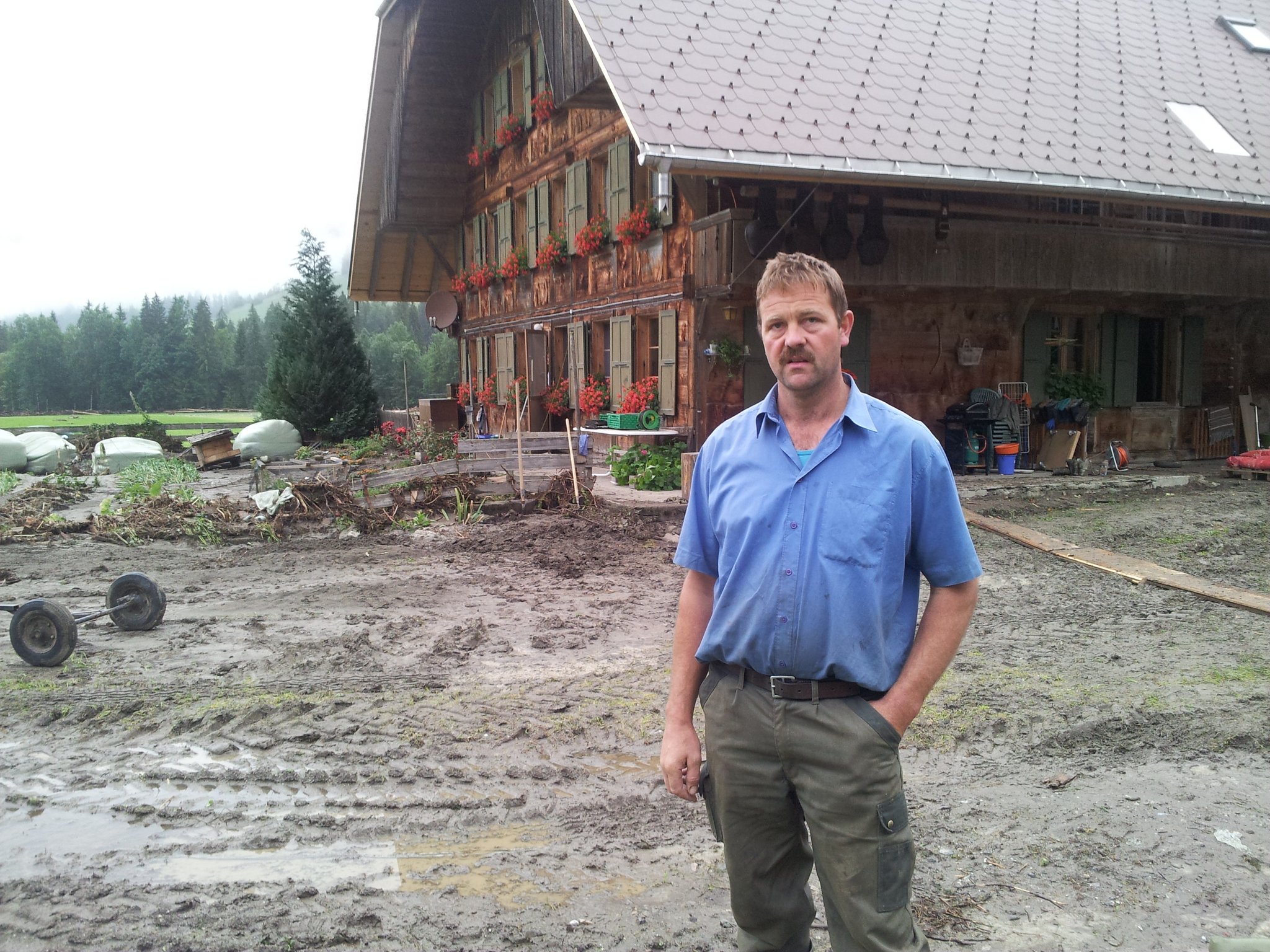 Der Brunnen wurde vom Wasser davon getragen, ebenso das Jauchefass. Landwirt Hans Gerber gestern Mittwochmorgen vor dem Bauernhaus. Wasser und Schlamm liefen durch die Gebäude (nächstes Bild) ... (Bilder: Simone Barth)