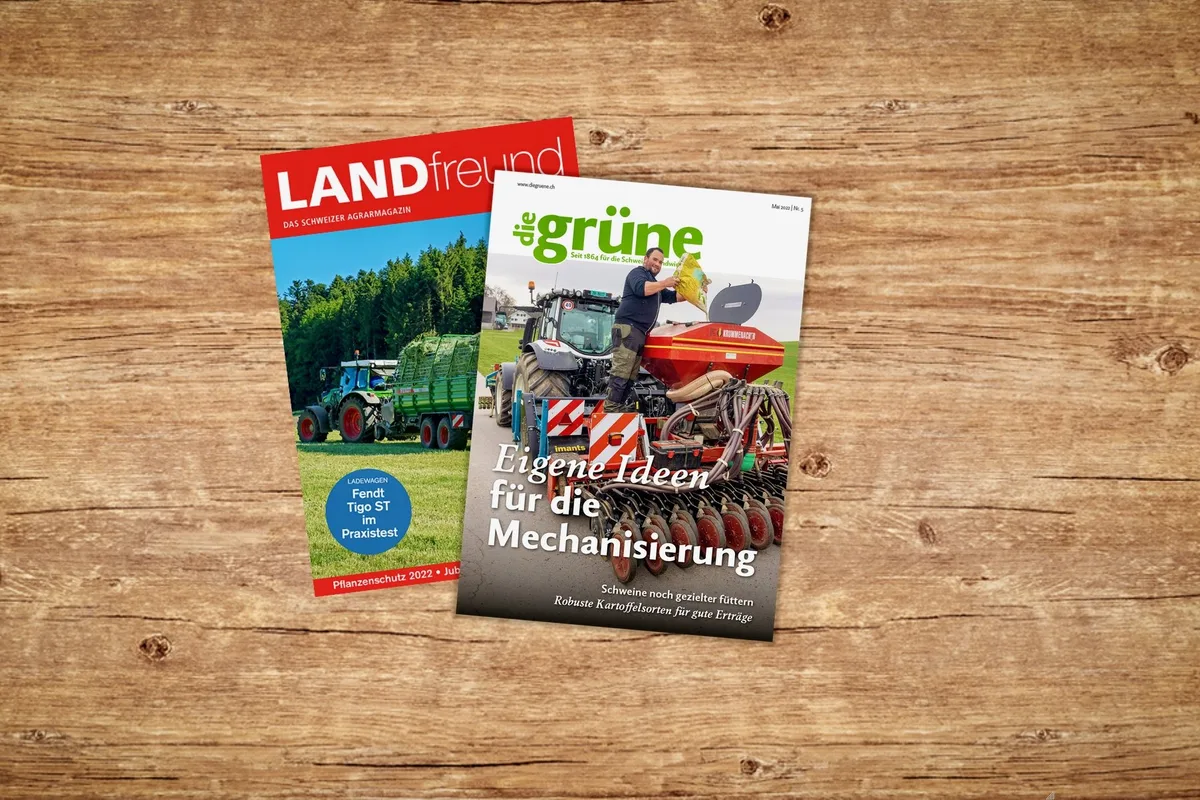 Die Titelblätter von Landfreund und die grüne auf einem Holztisch.