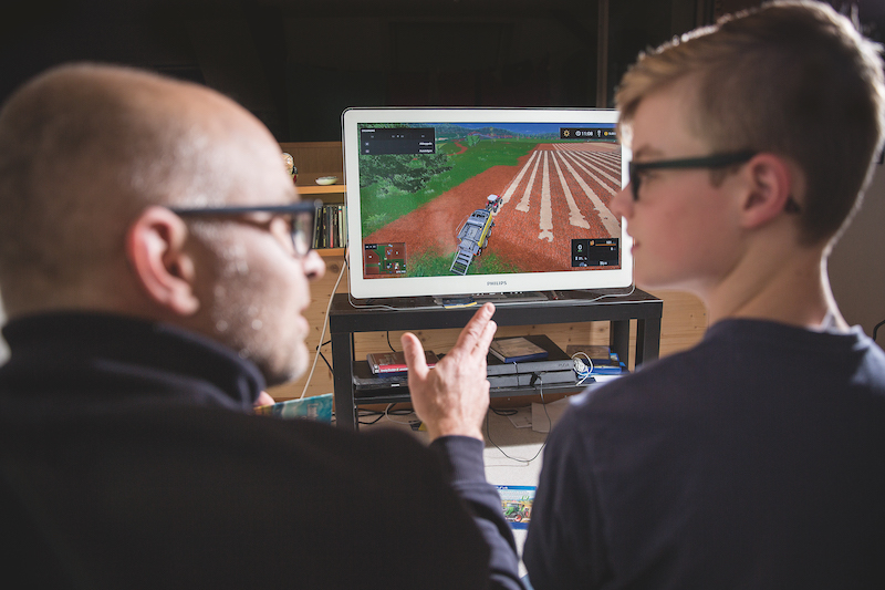 David Eppenberger diskutiert mit seinem Sohn über die Landwirtschaft dank dem Landwirtschafts-Simulator. (Bild Mareycke Frehner)