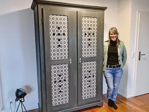 Jasmin Rupp neben einem alten Schrank, dem sie einen neuen Look verpasst hat.