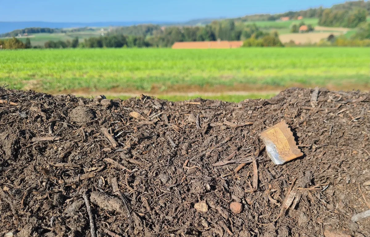 Mikroplastik-im-Boden An einer Kompostmiete am Feldrand sind diverse Verpackungen und Fitzelchen von Plastik zu sehen.
