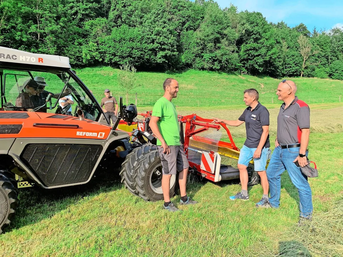 Reto Hurter von HW Landtechnik in Buonas, Andreas Enzler von Agromont und René Wismer, Inhaber HW Landtechnik (v.l.)  beim Bandschwader von Pöttinger, angehängt am Reform H70 R.