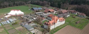 Übersicht des Schwand-Areals. Zum Verkauf steht unter anderem das grosse ehemalige Schulgebäude im Vordergrund. Der Landwirtschaftsbetrieb dagegen steht nicht zum Verkauf.