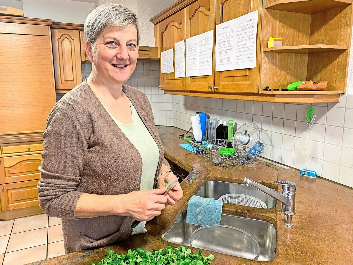 5e3c01dee620ee90d60c766197b44aeed37898fddf6d4d42465cd11240e30715 Sandra Bucher hat die Jodellieder an die Küchenschränke geheftet und übt während des Rüstens.
