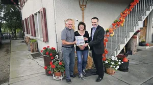 Urs Schneider (rechts) übergibt den Hauptpreis, eine Reise nach Wahl, symbolisch an Hans und Sonja Reinhard.