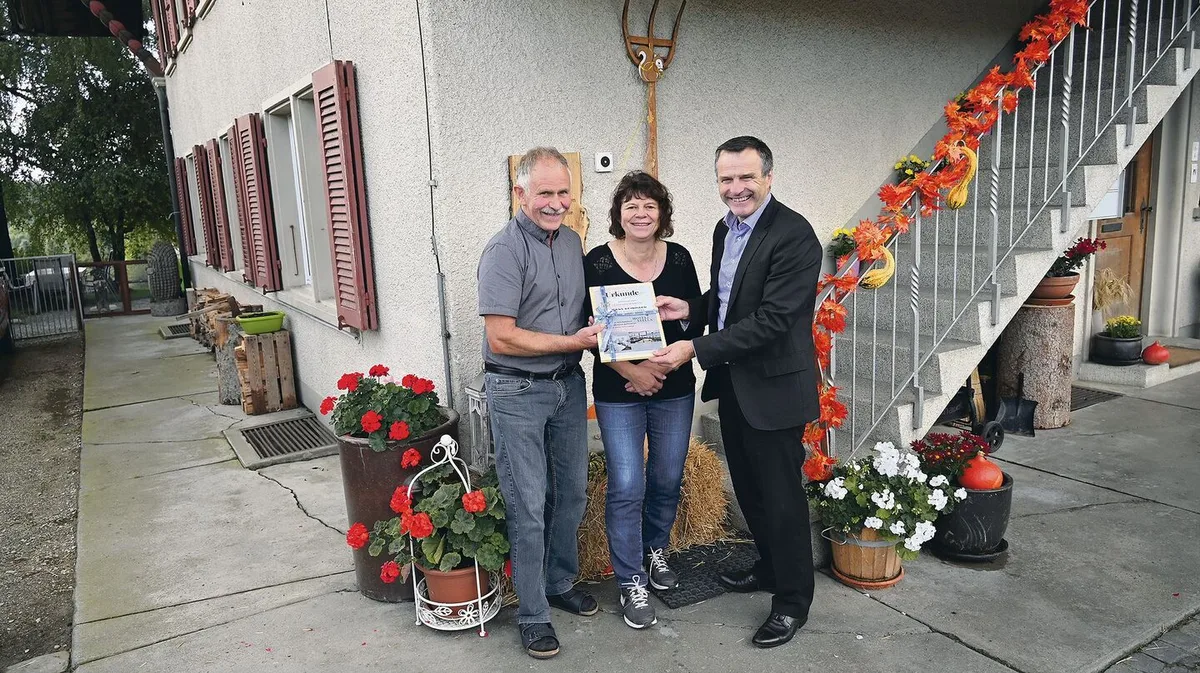 0e4848b53c282bd373e654d1a71360cb893eabda75bc3ecc4b6d8e9e845c375c Urs Schneider (rechts) übergibt den Hauptpreis, eine Reise nach Wahl, symbolisch an Hans und Sonja Reinhard.