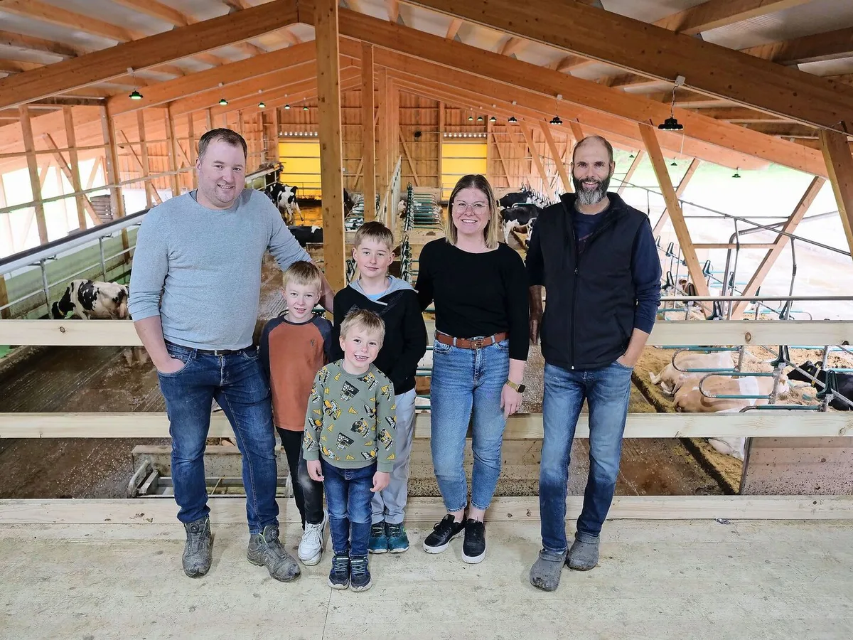 6a86a2cbeb85a689926af165357ad48b66ae44c683edf4e3fe56db103b127b98 Martin und Andrea Blaser mit ihren Kindern Niklas, Magnus und Linus sowie Markus Schafroth (v. l. n. r.) in ihrem neu gebauten Stall. Ganz links ist das obenliegende Futterband zu sehen.