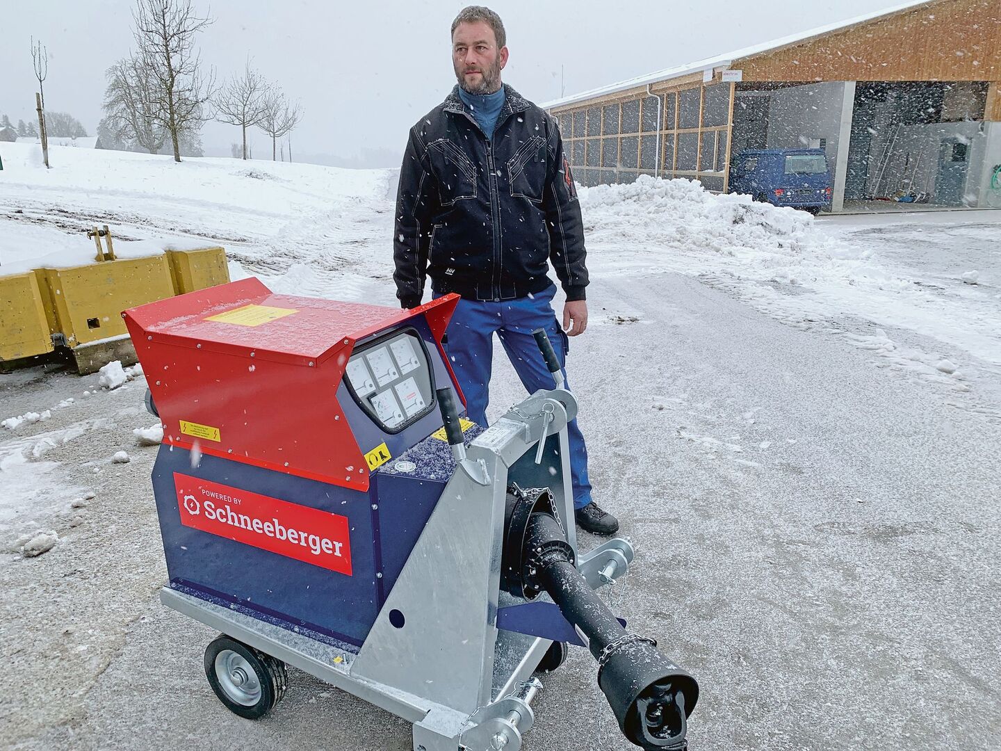 Passend zum Schneegestöber: Landwirt Beat Weltert vom Leidenberg, Grosswangen LU, mit dem neuen Schneeberger-Notstromaggregat. Im Hintergrund die Pouletmasthalle.