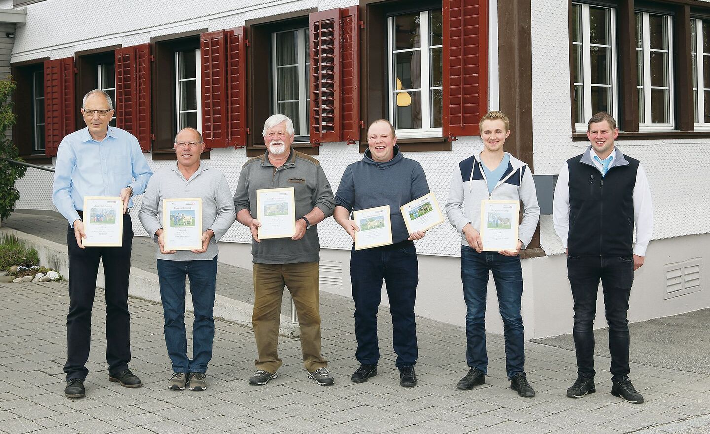 Vier der anwesenden Züchter der 100 000er-Kühe mit Braunvieh-Schweiz-Direktor Lucas Casanova (l.) und Cyrill Gauch (r.).