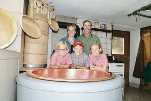 Myrtha und Siegfried Fischli mit den Kinder Nina, Marc und Sara (v. l. n. r.) hinter dem Kessi, in dem sie den Alpziger herstellen.(Bilder Barbara Schirmer)