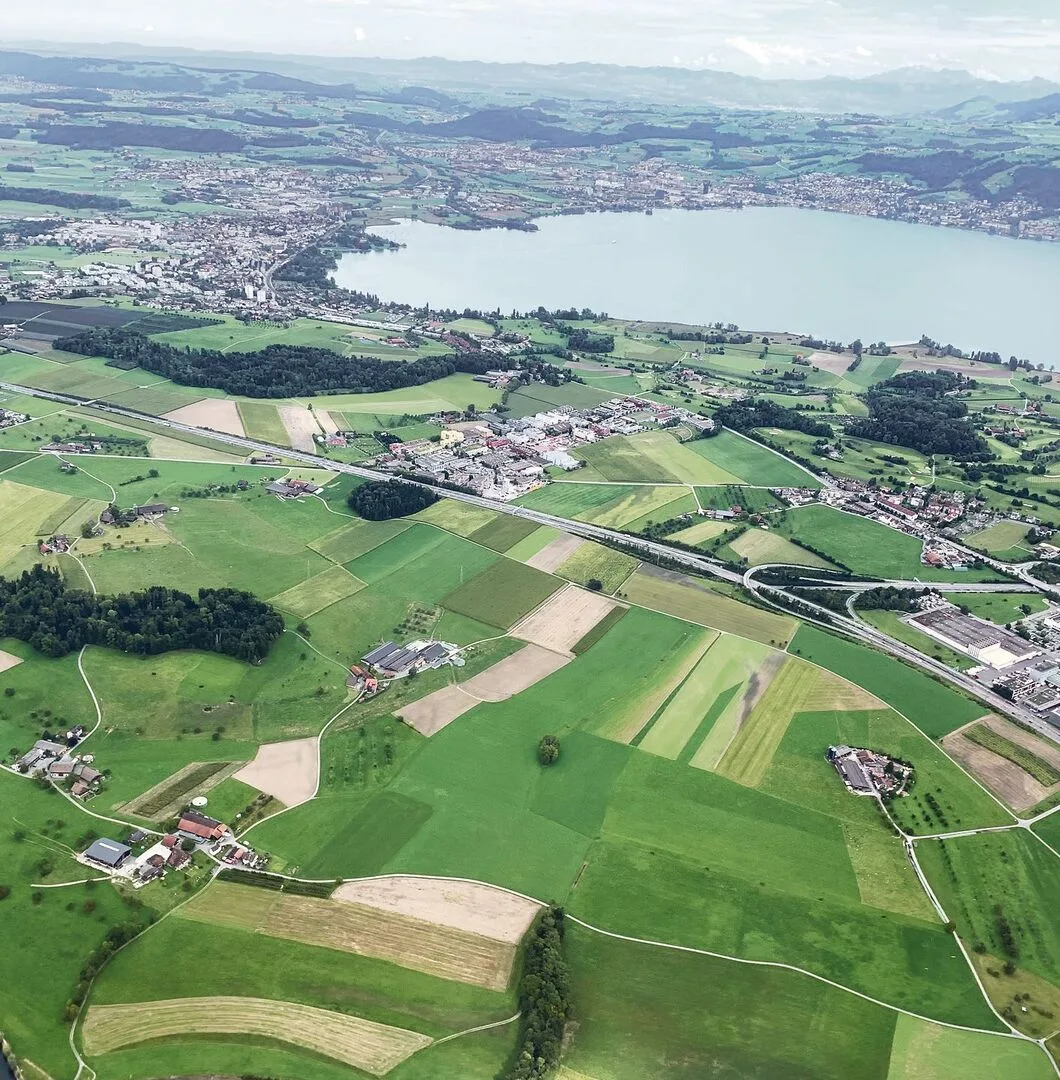 e1004cad5e99d6bf483c7fe61da70ff77447604710aeacbf66560e27bc031c0b Blick von den Landwirtschafts- und Siedlungsflächen bei Rotkreuz Richtung Zugersee.