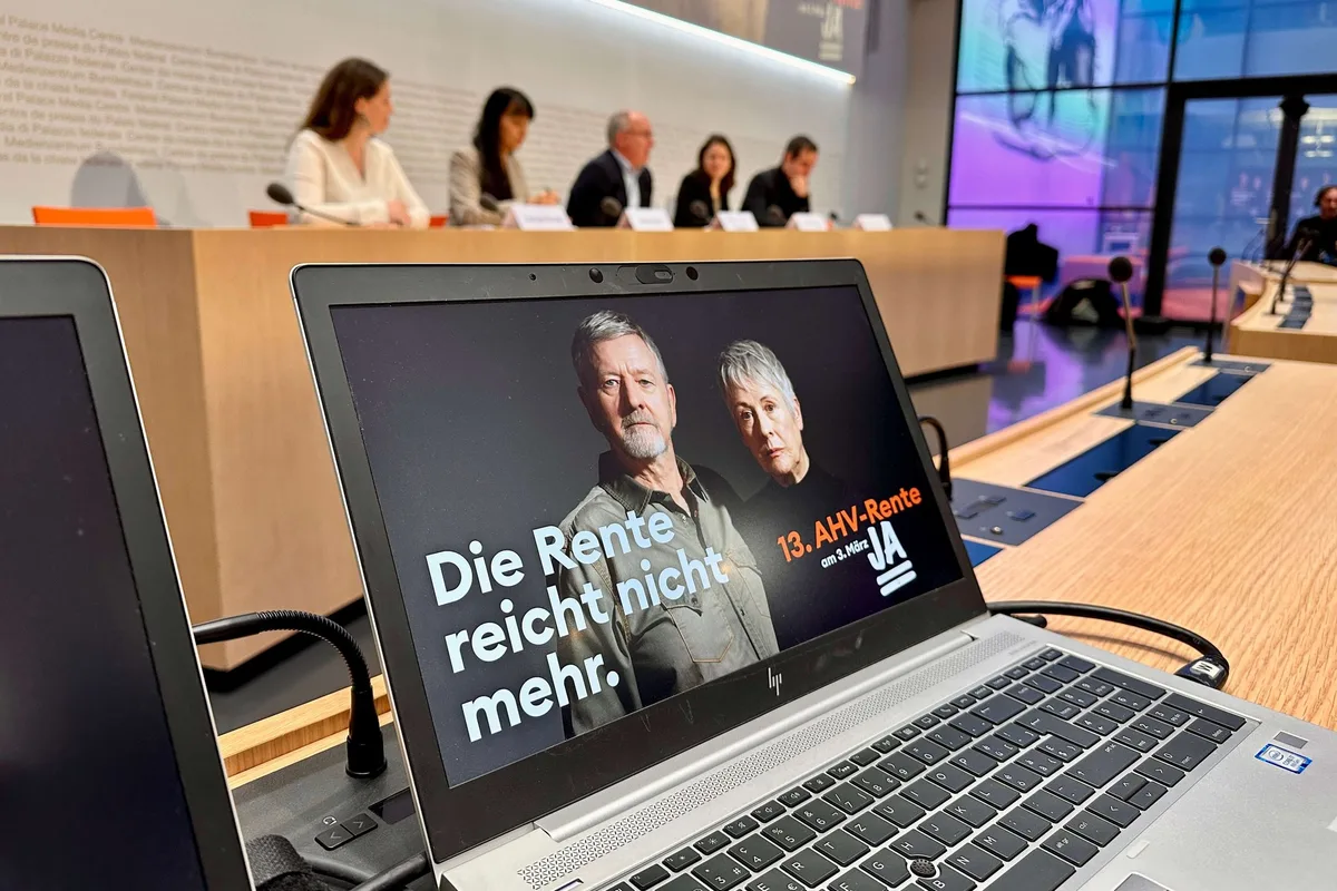 13_ahv_rente_kampagnenstart Das Sujet der Initiative für eine 13. AHV-Rente während der Lancierung der Kampagne. Im Hintergrund SGB-Präsident Maillard und SP Co-Präsidentin Meyer.