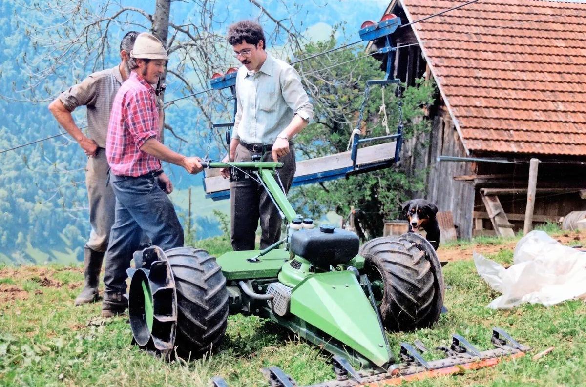 15e3be62fe15cbe189966d7f9061b5c68aa1df3766fb439105945ff668ac87ba Hans Jost (r.) bei den ersten Instruktionen zu seiner Entwicklung, dem Steilhangmäher «Kolibri» in Bürglen UR.