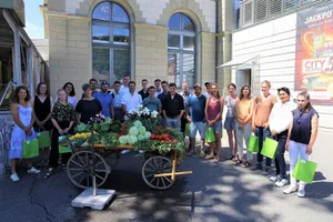 Die Diplomandinnen und Diplomanden versammeln sich fürs Foto um einen Wagen mit dem, wofür sie in Zukunft tagtäglich arbeiten werden: frisches Gemüse aus der Region.
