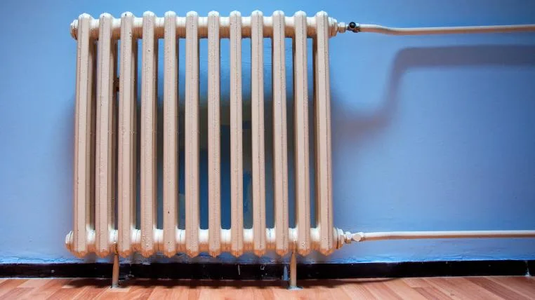 b35f80b7e0d56e2d2c4876a366dbdfed21d8698b Radiator vor blauer Wand
