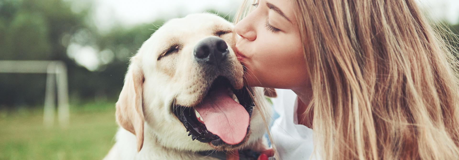 Frau küsst Hund