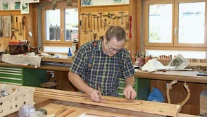 Hansruedi Blaser schneidet Riemen für ein Zaumzeug zu.